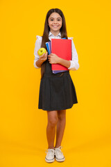 Back to school. Full length of teenager school girl with backpack hold aplle ready to learn. School children with school bag on isolated yellow studio background.