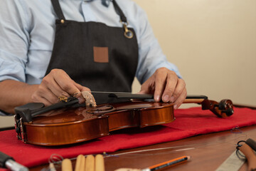 Cropped photo of an artisan repairing a violin