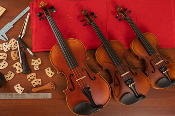 Top view of three violins in a workshop