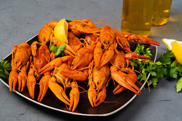 Delicious red boiled crayfish on a gray table, with parsley and lemon. top view