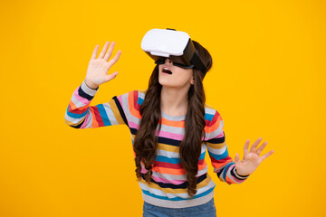 Excited teenager using VR headset. Girl play vr video game. Digital future and innovation. Child in virtual goggles. Excited teen girl with virtual reality goggles headset isolated on yellow.