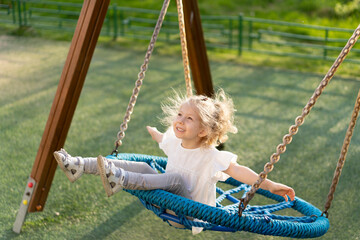 happy little girl on a big swing