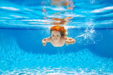 Child swim under water in sea. Kid swimming in pool underwater. Happy boy swims in sea underwater,...