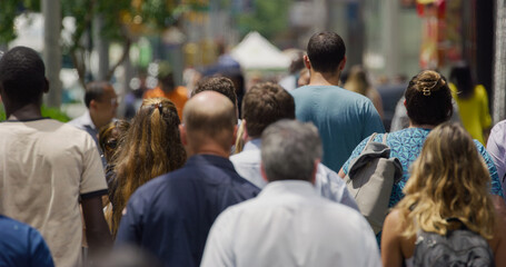 Crowd of people walking city street
