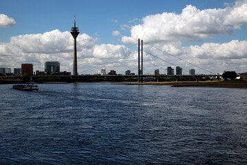 Fototapeta premium TV tower in Düsseldorf near the river against a blue sky with white clouds