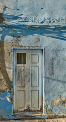 Exterior of a decaying brick building with peeling paint in Santa Cruz de La Palma. Architectural details of an abandoned rustic property with a damaged, aged door or entrance outside