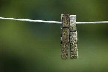 Old pegs on a clothesline outdoors against a blurred background with copy space. Details of two...
