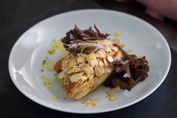 Salmon dish with almond flakes and dark leaves , Porto Alegre, RS, Brazil
