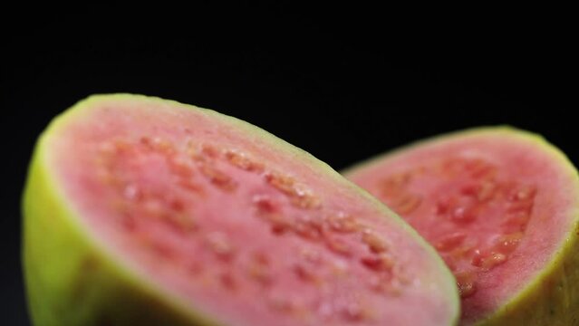 Closeup of sliced red guava rotating.