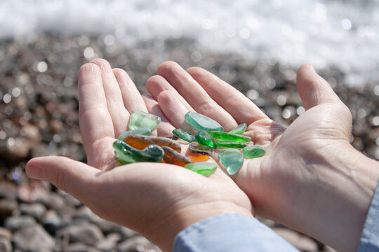 Sea glass pieces in the hands of a young woman habitat pollution ecology of Lake Baikal