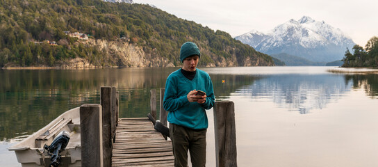 Joven turista sacando fotos con su celular y enviándole  a sus amigos durante un paseo por la...