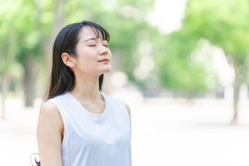 Fototapeta premium 新緑の中の女性（横顔・森林浴・エコ・SDGs） 