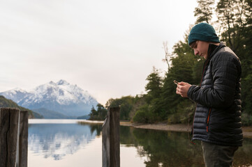 Niño enviando un mensaje a su madre durante un paseo por el Parque Nacional Nahuel Huapi en la...