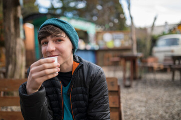 Joven feliz disfrutando de un chocolate caliente en San Carlos de Bariloche.