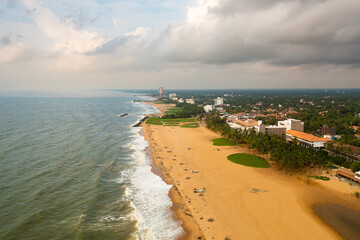 Seascape with tropical sandy beach and blue ocean. Negombo, Sri Lanka.