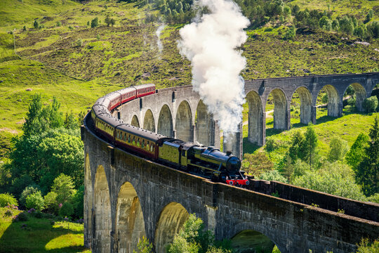 Glenfinnan Railway Viaduct In Scotland With The Steam Train Passing Over