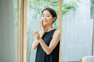 手鏡を持ち肌の調子を実感する美しい日本人女性