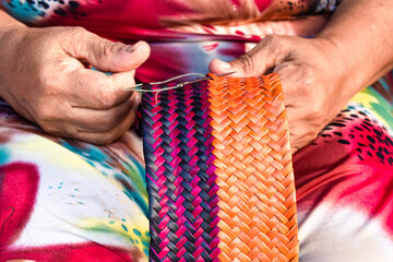 Artesanato colorido com palha feito por mulheres brasileiras indígenas no litoral baiano e...