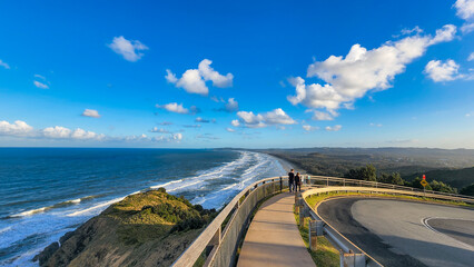 People walking along path at Cape Byron with view over Tallow Beach at Byron Bay, NSW Australia