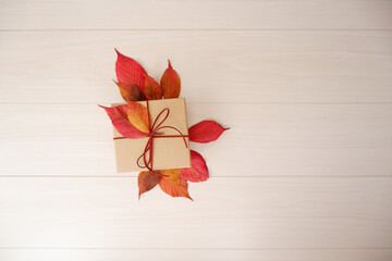 Autumn greeting background. Colorful autumn leaves and gift box composition on white wooden background. Thanksgiving, Fall greeting, autumn festival background and Banner design elements.