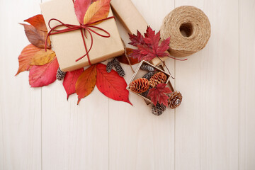 Autumn greeting background. Colorful autumn leaves and gift box composition on white wooden background. Thanksgiving, Fall greeting, autumn festival background and Banner design elements.