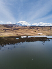 Aerial view of Huaypo Lake. Water source in the high Andes of Cusco Peru. Sunny day in Andean rural landscape.