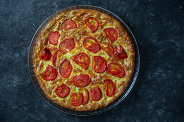 Delicious vegetarian zucchini pie with red tomato, top view, close up