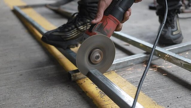 El hombre trabaja cerca de la sierra circular. Las llamas salen del metal caliente. El hombre trabaj&oacute; en el acero.