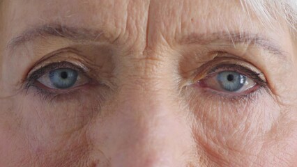 Closeup for optical vision exam of a senior woman looking for glasses to improve her eyesight. Eyes of a mature female at her optometrist appointment for new prescription spectacles or contact lenses