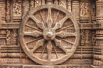 Fototapeta na wymiar Chariot wheel from Konark Sun Temple, which is a 13th-century CE Sun temple at Konark about 35 kilometres northeast from Puri city on the coastline in Puri district, Odisha, India.