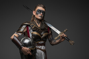 Portrait of ancient woman warrior in nordic style holding helmet and sword.