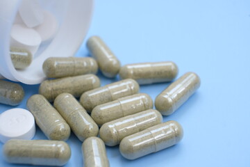 Pharmaceutical medical pills, blister-packaged capsules, and tablets strewn across a blue background.