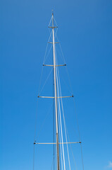 White Sailboat Mast Against a Blue Sky Background.