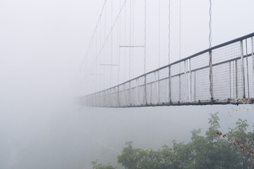 Fog view on the Khndzoresk suspension bridge in the cave city in the mountain rocks. Armenia...