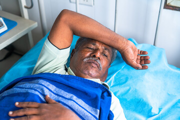 Elderly senior man suffering from insomnia while admitted to hospital - concept of mental illness,...