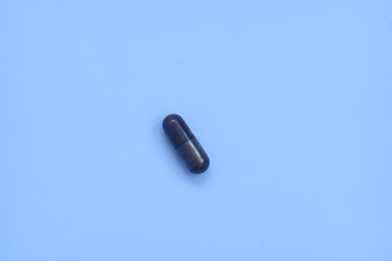 Pharmaceutical medical pills, blister-packaged capsules, and tablets strewn across a blue background.