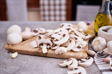 champignon mushrooms on wooden cutting board at domestic kitchen