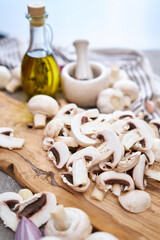 champignon mushrooms on wooden cutting board at domestic kitchen