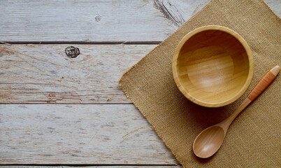 Top Views of Empty wooden cup and wooden spoon and sackcloth on sacks on a wooden background, The concept of cooking utensils made of wood.