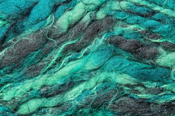 Close-up of colourful merino wool emerald and grey striped background. Abstract handmade craft knitted yarn texture pattern flatlay. Holiday card concept. Idea for f elting, needlework, hobby. Mock up