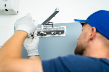 Obraz premium Handyman Installing And Fixing Automatic Door Closer
