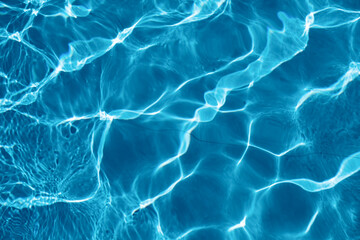 Ripple water surface with sun glare in a swimming pool