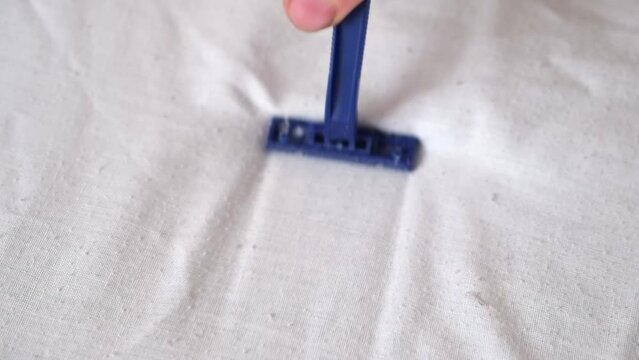 A man removes fabric pills using a disposable shaving machine. A razor for removing pellets.
