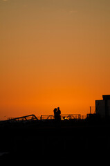 Naklejka premium lovingly embracing lovers in a harbour at sunset