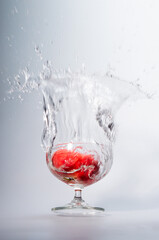 Fruits fall into a glass of water, splashes