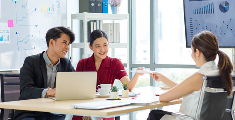 Group of millennial Asian multinational multicultural male and female businessman businesswoman teamwork in formal suit sitting smiling brainstorming meeting together in office conference room.