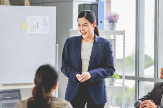 Closeup shot of Asian pretty happy cheerful  female businesswoman intern trainee in casual suit standing smiling in company office