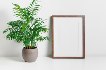 Vertical frame mockup with homw plant in pot, blank mockup for artwork
