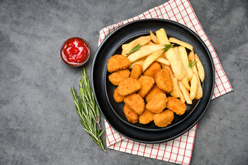 Chicken nuggets with potatoes french fries and ketchup