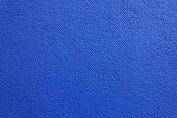 Texture of wall with coarse vibrant blue roughcast finish © Anna